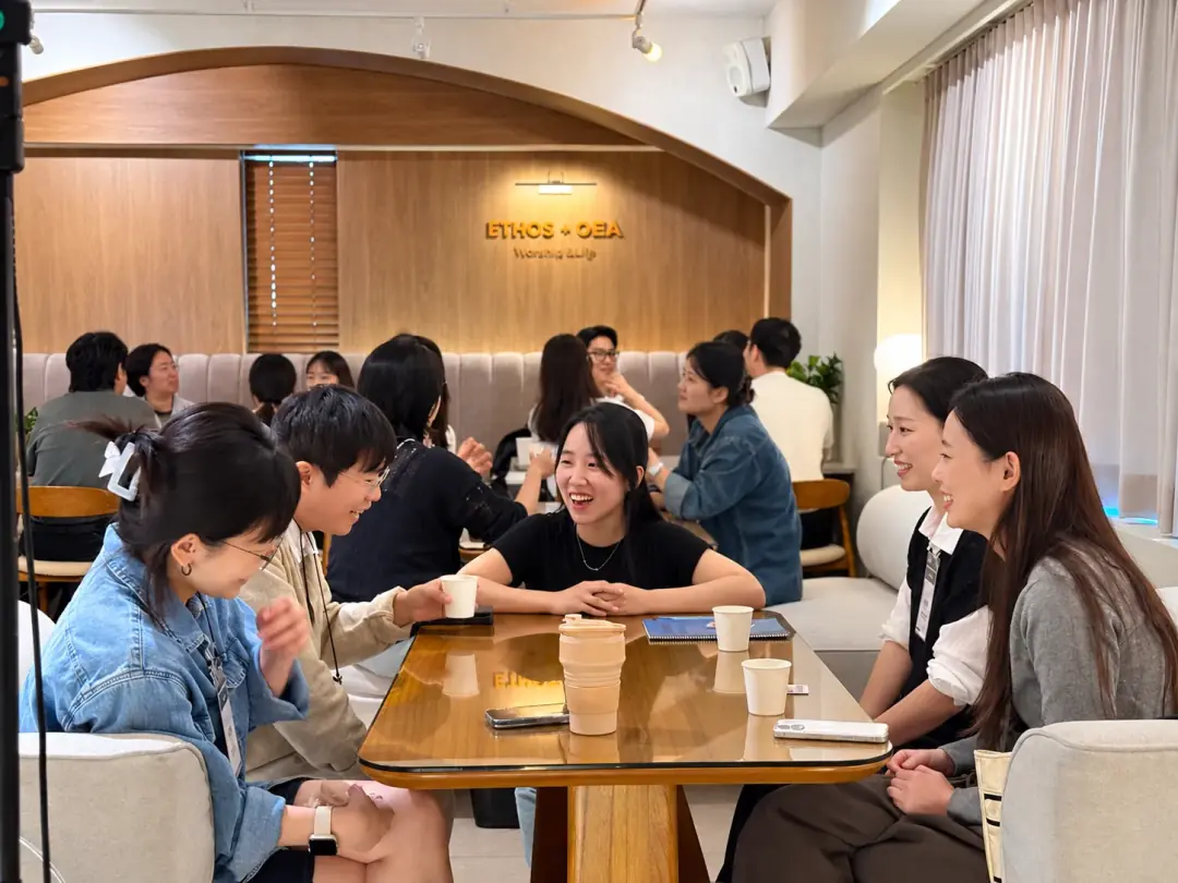 멘토 율과 Y-BAR 365 동료들이 테이블에 둘러앉아 웃으며 대화하는 모습
